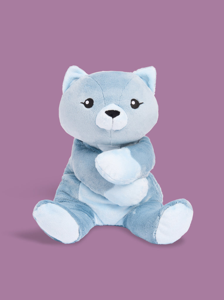 A blue cat stuffed animal sits facing forward on a purple background