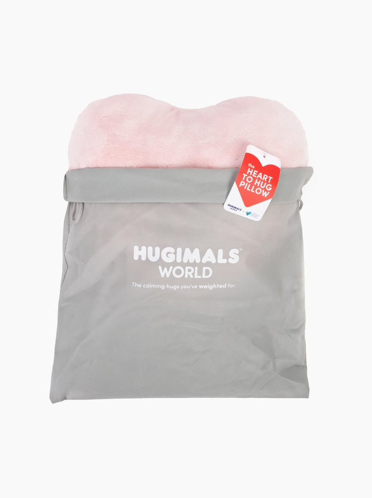 This image shows a pink Heart to Hug Pillow emerging from a light gray Hugimals World gift bag.
