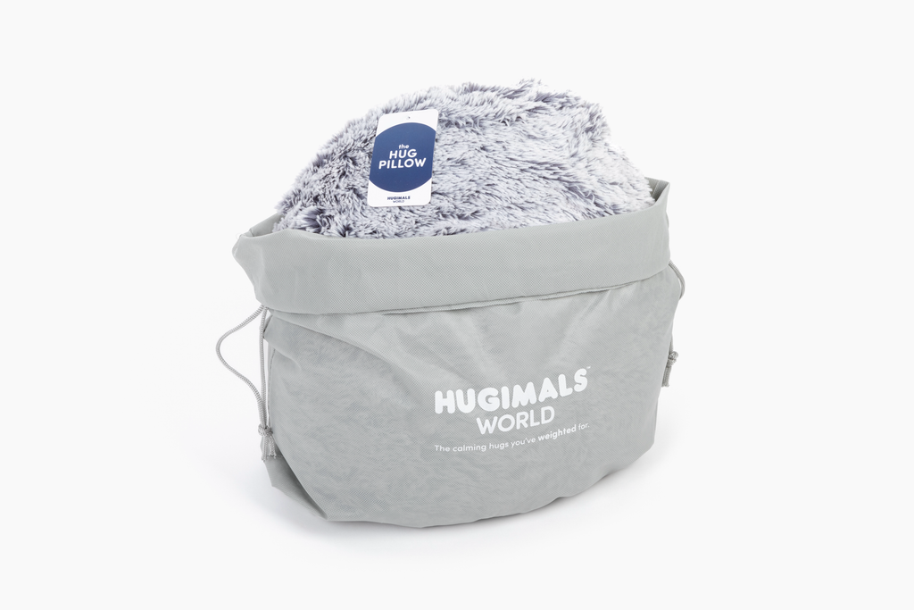 Image showing round grey Hug Pillow inside a branded gray gift bag 