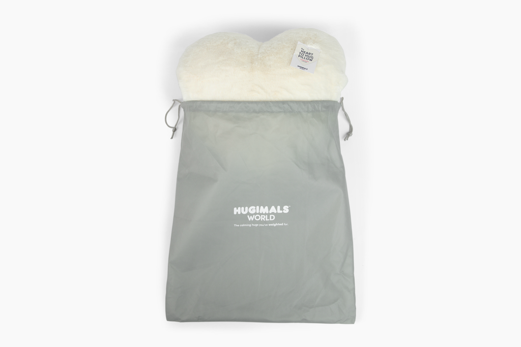 Ivory Super Sized Heart to Hug Pillow emerging from gray gift bag